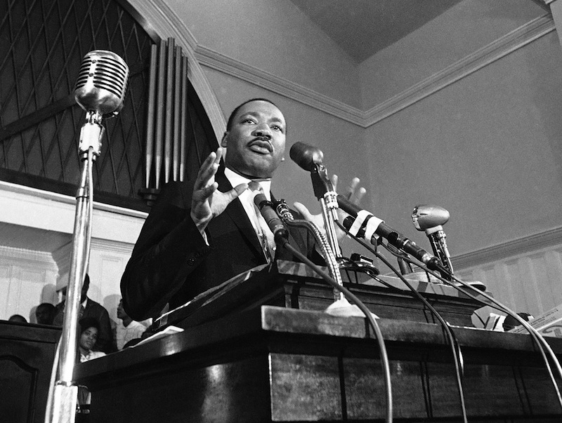 In this 1960 file photo, Martin Luther King Jr. speaks in Atlanta. A 1960 recording of an interview with King never before heard in public is up for sale. The tape was recorded by a Chattanooga man hoping to write a book and captures King talking about his trip to Africa, and his certainty that the child he and Coretta Scott King were expecting would be a boy. (AP File Photo) Microphone Communication Looking Away Standing Authority Gesturing