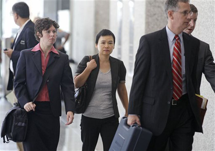 Hanjuan Jin, center, leaves the federal courthouse Wednesday, Aug. 29, 2012, in Chicago, after being sentenced to four years in prison for stealing trade secrets from Motorola. Jin, who worked as a software engineer for Motorola Inc. for nine years, was stopped during a random security search at Chicago's O'Hare International Airport on Feb. 28, 2007, before she could board a flight to China. Prosecutors say she was carrying $31,000 and hundreds of confidential Motorola documents, many stored on a laptop, four external hard drives, thumb drives and other devices. (AP Photo/M. Spencer Green)