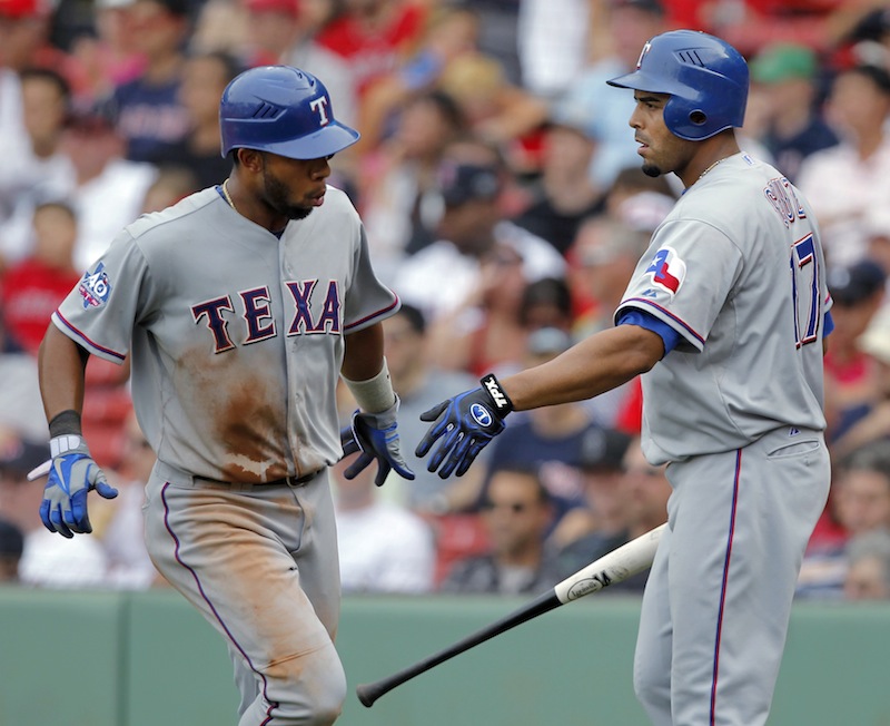 Texas Rangers' Elvis Andrus, left, is welcomed at home by Nelson Cruz, right, as he scores on a sacrifice fly by Adrian Beltre in the ninth inning of a baseball game at Fenway Park, in Boston, Wednesday, Aug. 8, 2012. The game winning run gave the Rangers a 10-9 win over the Boston Red Sox. (AP Photo/Steven Senne)