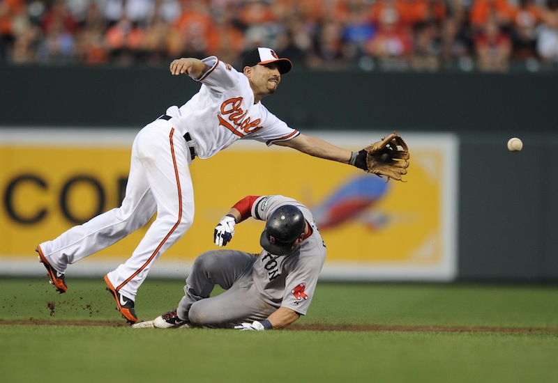 Boston Red Sox's Nick Punto, bottom, is slides safely into second on a wild pitch as Baltimore Orioles second baseman Omar Quintanilla, top, reaches for the ball during the second inning of a baseball game on Thursday, Aug. 16, 2012, in Baltimore. (AP Photo/Nick Wass)