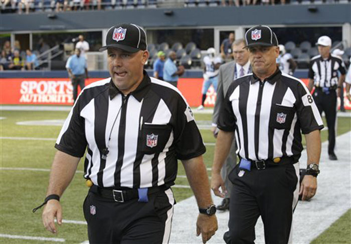 This Aug. 11, 2012 file photo shows replacement officials taking the field at the start of an NFL football preseason game between the Seattle Seahawks and the Tennessee Titans, in Seattle. The NFL will open the regular season with replacement officials. League executive Ray Anderson has told the 32 teams that with negotiations remaining at a standstill between the NFL and the officials' union. The replacements will be on the field beginning next Wednesday night, Sept. 5, 2012, when the Cowboys visit the Giants to open the season. (AP Photo/Rick Bowmer, File)