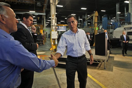 Republican presidential candidate Mitt Romney greets with Warren Young, chief executive officer at Acme Industries, as he campaigns in Elk Grove Village, Ill., today.