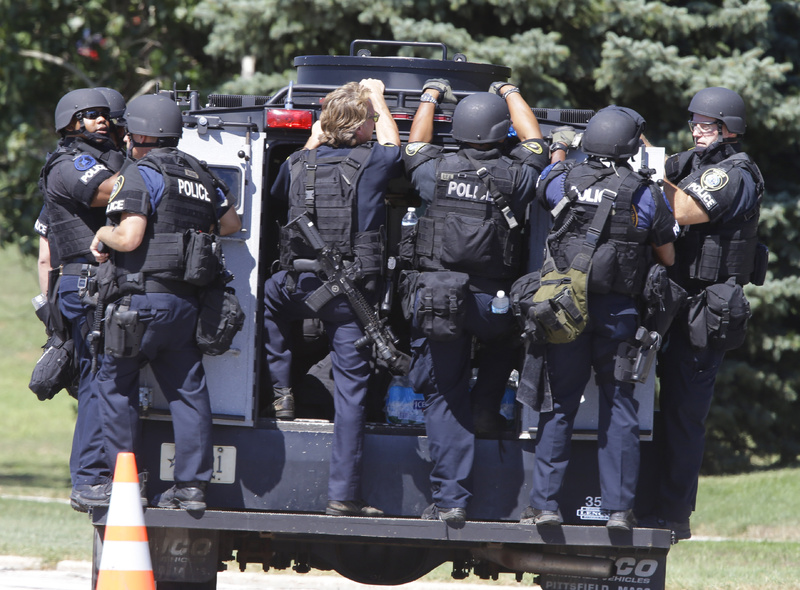 Police personnel move outside the Sikh Temple in Oak Creek, Wis, where a shooting took place Sunday.