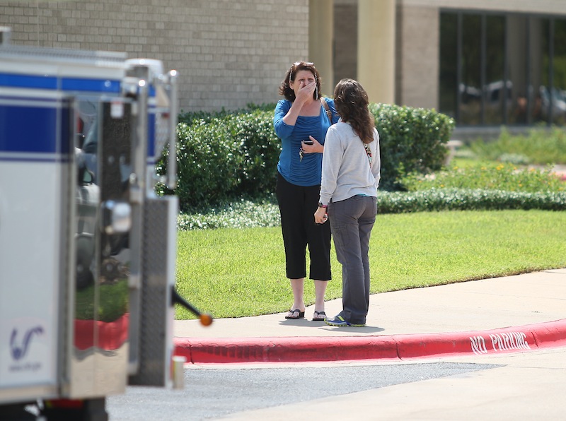 A woman reacts outside of the College Station Medical Center, Monday, Aug. 13, 2012, in College Station, Texas where five victims were brought, following a shooting near the Texas A&M campus. A gunman and a law enforcement officer were among three people killed Monday in a shooting near a Texas university campus, police said. (AP Photo/Houston Chronicle, Karen Warren)