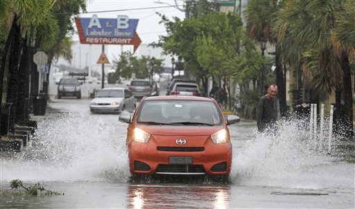 A car goes through a flooded street due to heavy rains in Key West, Fla., Sunday as heavy winds and rain hit the northern coast.