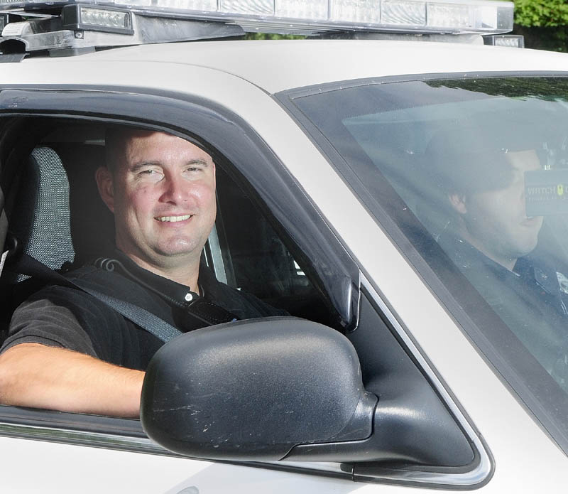 Greg Smith, the Augusta Police Department's intensive case manager, sits in the passenger side of a police cruiser driven by Officer Nathan Walker on Wednesday afternoon.