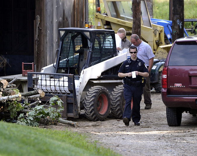 Officer Benjamin Davis of the Cape Elizabeth Police Department leaves the scene of his investigation of an explosion at a residence in Cape Elizabeth off Harvest Lane on Wednesday. One man was injured and taken to the hospital.