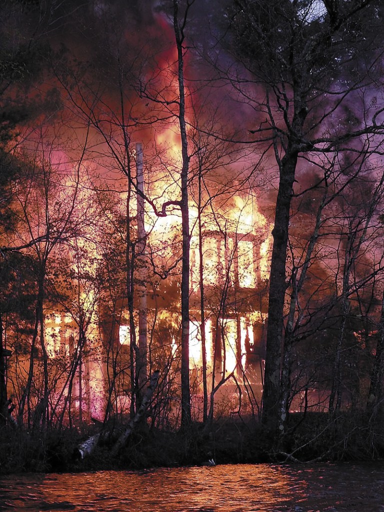 A house on Coon Island in Togus Pond goes up in flames on May 4, 2012. James Croxford has admitted setting the fire that caused an estimated $150,000 in damage.