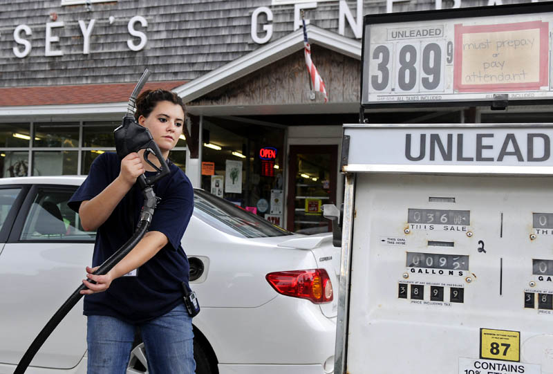 Staff photo by Andy Molloy MILEAGE: Philicity Palmer replaces a gas pump Tuesday after filling a customer's car at Hussey's General Store in Windsor. The regulations finalized Tuesday by the Obama administration require the fleet of new cars and trucks to average 54.5 miles per gallon in 13 years, up from 28.6 mpg at the end of last year.