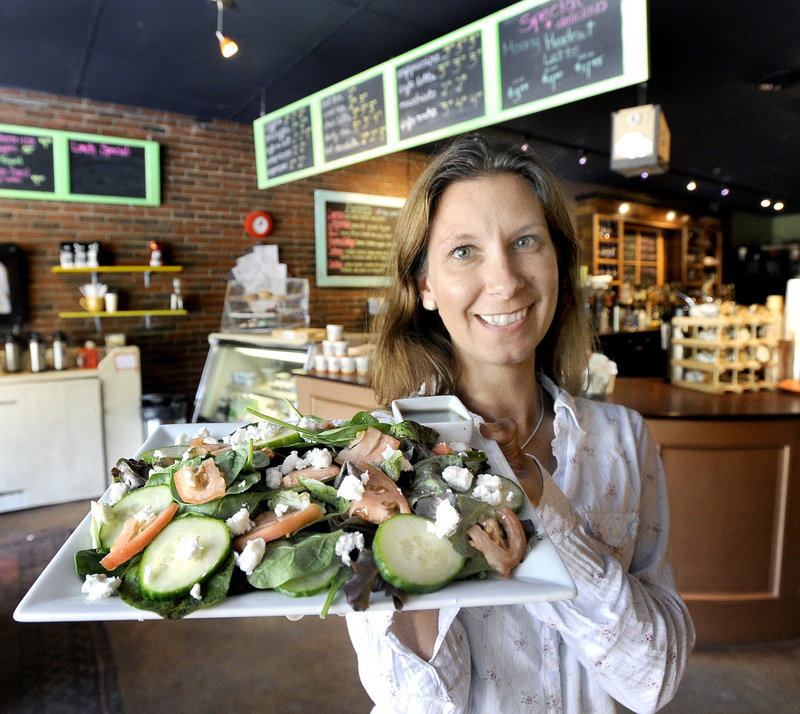Dawn LaPointe, co-owner of The Local Buzz on Ocean House Road in Cape Elizabeth, heads toward a table to serve a customer a salad of mixed greens, cucumber, tomato and goat cheese.