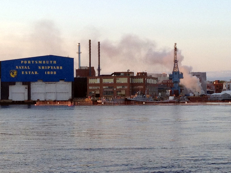 Smoke rises from the burning nuclear submarine at the Portsmouth Naval Shipyard in Kittery May 23. A civilian employee has been charged with setting a fire that caused $400 million in damage.