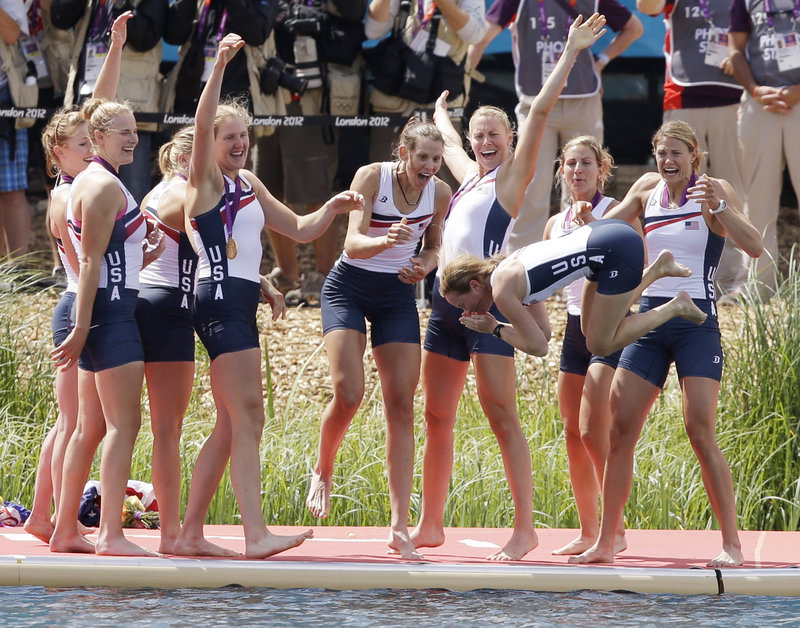 Eleanor Logan of Boothbay Harbor, fourth from left with arm raised, celebrates with her teammates Thursday as coxswain Mary Whipple gets tossed into the water following a gold-medal victory in the women’s eight rowing event at the Olympics. It was a repeat gold for the team.
