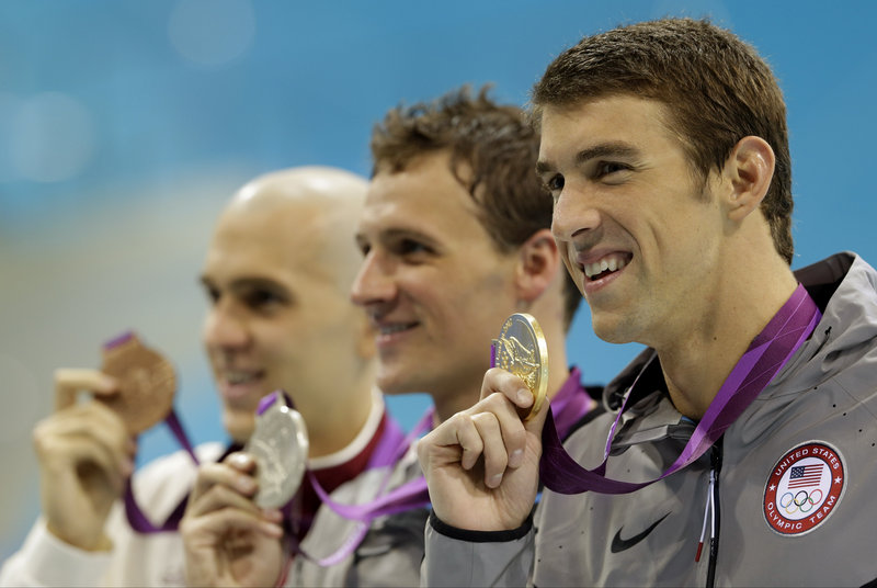 Michael Phelps, right, poses with Ryan Lochte, center, and Laszlo Cseh of Hungary after their 1-2-3 finish Thursday in the 200-meter individual medley. It was the final duel between Phelps and Lochte, two longtime rivals.