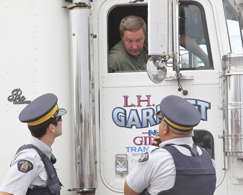 Maine truck driver Leonard Garnett of Steuben talks with police at a Shediac, New Brunswick, processing plant after fishermen blocked his truck with the intention of leaving his load of lobsters to rot.