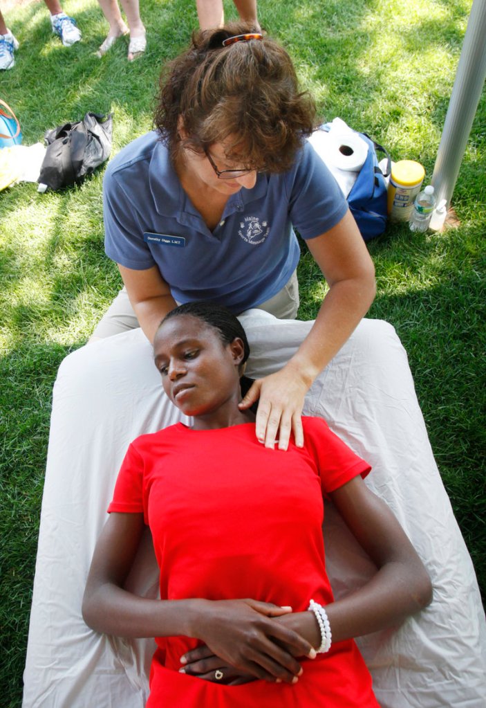 Margaret Wangari-Muriuki, an elite runner from Kenya, receives a massage from Dorothy Diggs after the press conference Friday for the TD Beach to Beacon 10K.