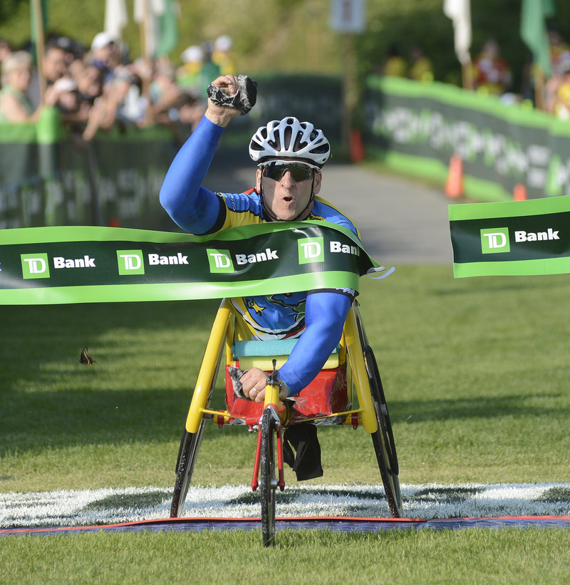 Craig Blanchette of Battleground, Wash., celebrates while crossing the finish line Saturday to capture the men’s wheelchair division of the Beach to Beacon 10K for the second time in three years.