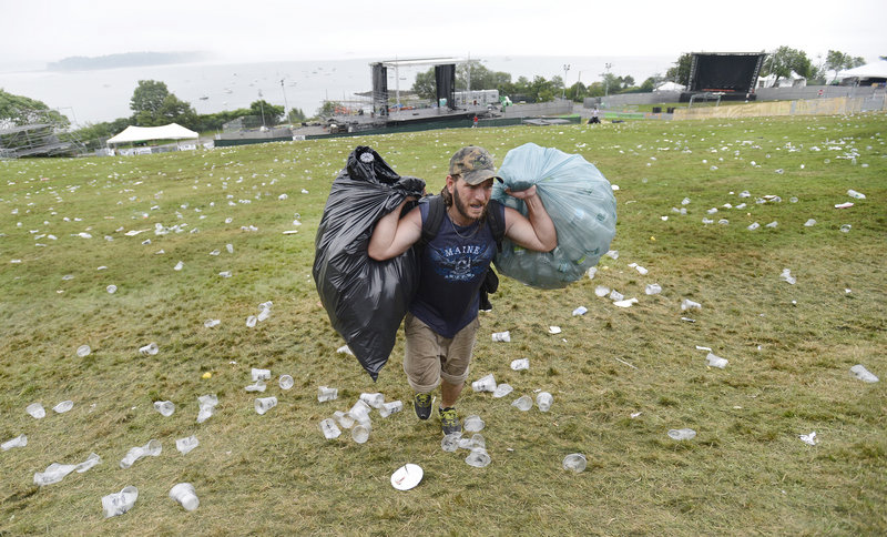 James Baldwin of Portland carries bags of returnable bottles and cans up the hill on the Eastern Prom, site of Saturday’s Mumford & Sons concert. City officials said they won’t know until Monday how much trash and recycling were generated by the event.