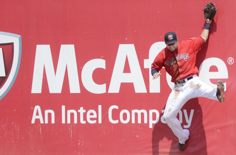 Portland’s Bryce Brentz crashes into the right-field wall at Hadlock Field as he makes a tough catch in the Sea Dogs’ win over the Erie SeaWolves on Sunday in Portland. The win gave Portland a three-game sweep.