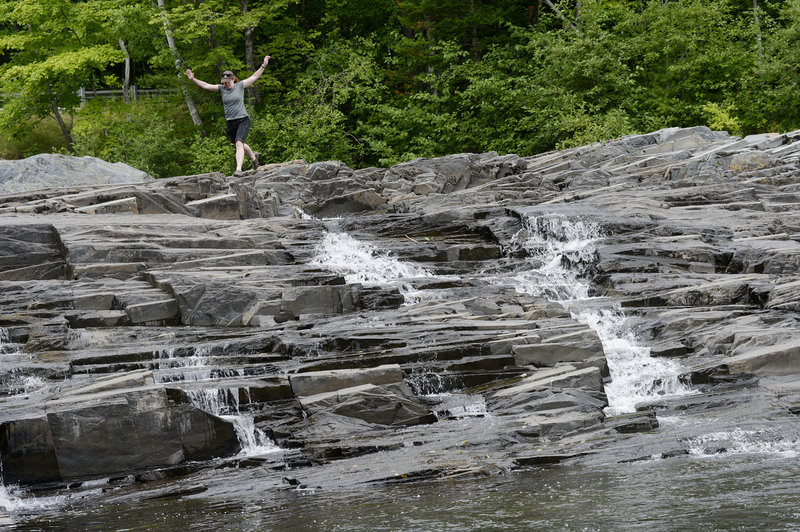 Maine Sunday Telegram staff writer Deirdre Fleming navigates the rocks while exploring Big Wilson Falls, one of more than 100 picturesque waterfalls in Piscataquis County.