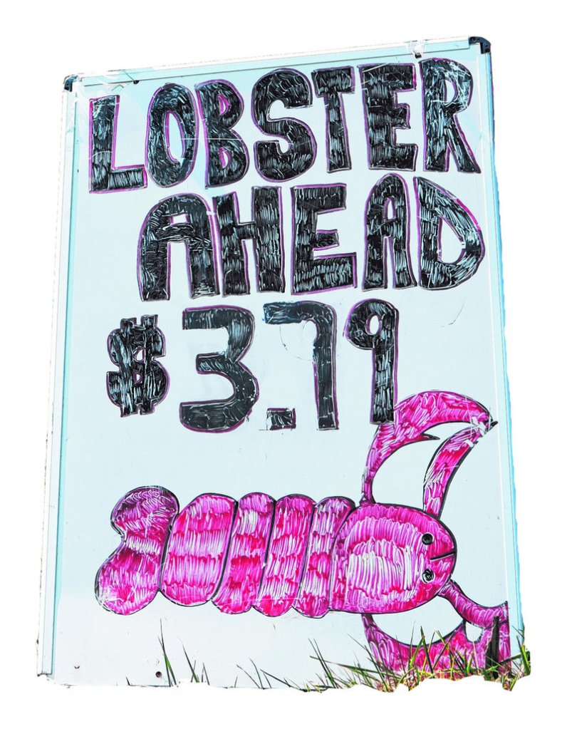 A sign on Commercial Street in Portland advertises the price per pound for lobster Thursday at Benny’s Lobster.