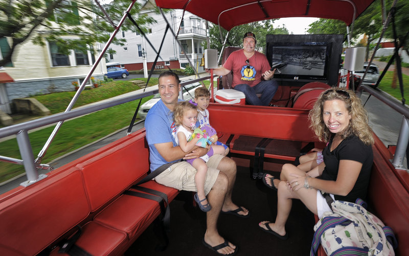 Ken Araujo and his family, residents of Acushnet, Mass., ride aboard a converted 1971 International Harvester fire truck on Friday during a tour conducted by Tim Lambert of the Portland Fire Engine Co.
