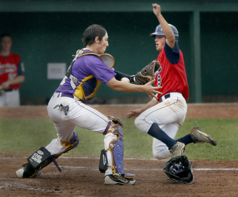 First Title catcher Nic Lops attempts to control the ball as Alex Lushkevich of Saratoga, N.Y., slides safely into home in the sixth inning Friday at Old Orchard Beach. First Title won, 10-1.