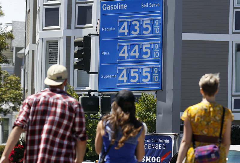 Pedestrians walk toward a Chevron gas station price board in San Francisco on Friday. Analysts say that without any further disruptions, such as refinery problems or hurricanes in the Gulf of Mexico, gasoline will probably begin dropping after Labor Day as refiners switch to cheaper blends and drivers hit the road less often.