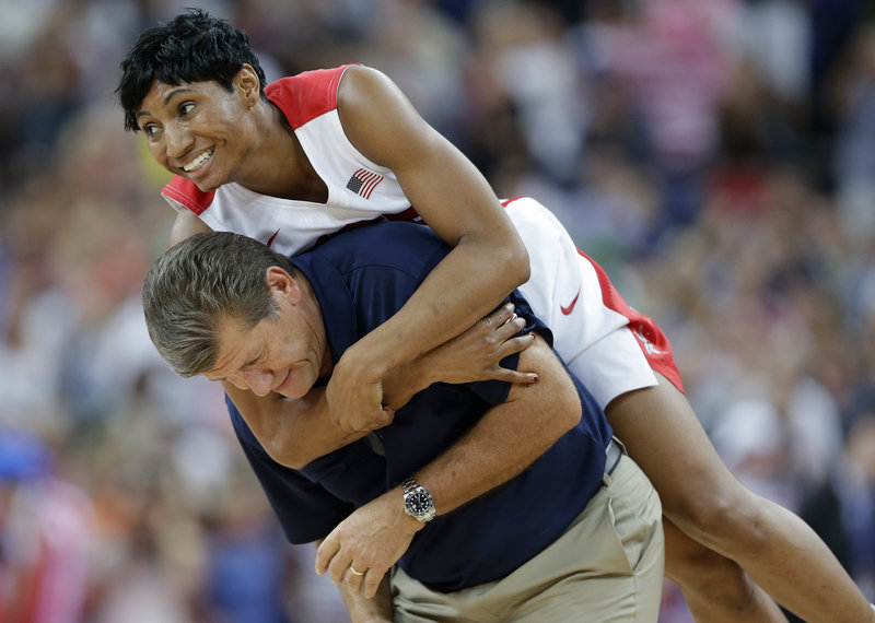 Angel McCoughtry jumps on the back of Coach Geno Auriemma after the United States captured its fifth straight women’s basketball gold medal Saturday with an 86-50 victory against France.