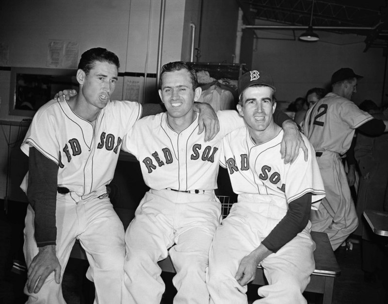 Boston Red Sox pitcher Mel Parnell, center, is flanked by teammates Ted Williams, left, and Johnny Pesky after a 4-1 win over the New York Yankees at Fenway Park in 1949. Pesky, who spent most of his 60-plus years in pro baseball with the Red Sox, was beloved by the team’s fans, and the right-field foul pole at Fenway is named after him.