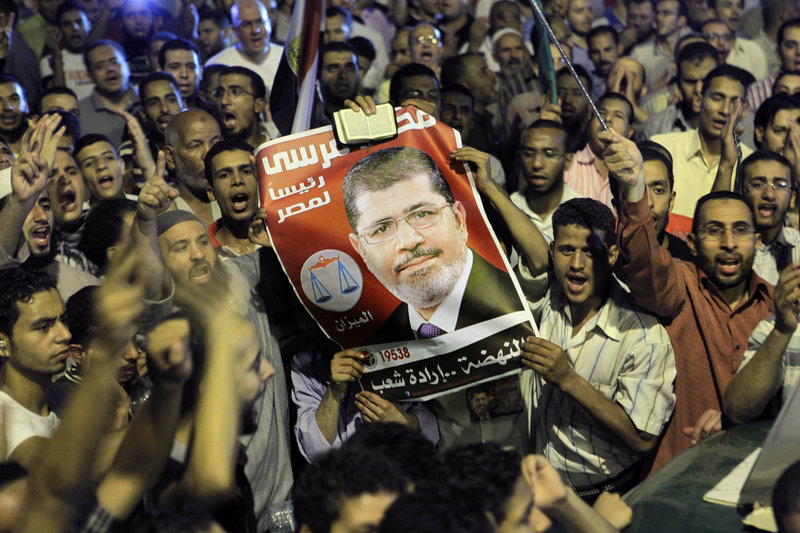 Thousands of supporters raise a poster of Egypt’s Islamist President Mohammed Morsi as they celebrate in Tahrir Square, birthplace of the uprising that ousted Hosni Mubarak 18 months ago, in Cairo late Sunday.