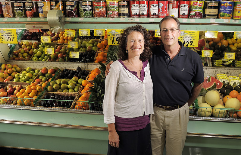 Alan Cardinal joins his wife, Sylvia Most, on Tuesday at Smaha’s Legion Square Market in South Portland. They will operate the grocery store and butcher shop together.