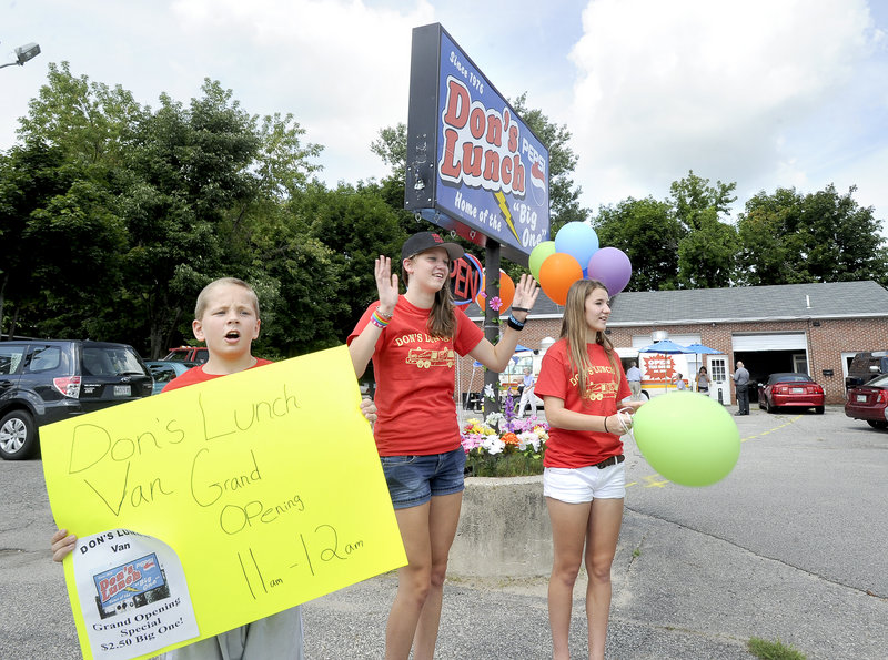 Christopher Vincent, 11, Amber Richards, 16, and Brianna Barlow, 15, catch the attention of passing motorists as the Richards family, who are original owners of Don’s Lunch Van in Westbrook, reopen the Main Street business Tuesday. The van was modeled after Rapid Ray’s in Saco.