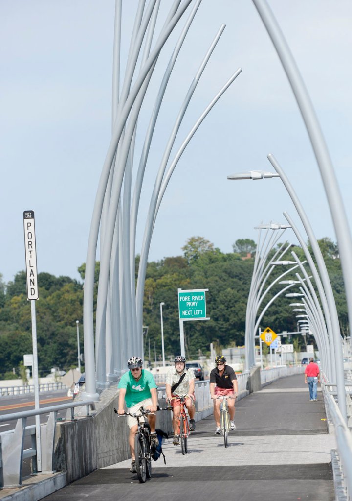 Bicyclists, including, left to right, Phil Goff of Arlington, Mass., Carl Eppich of South Portland and Paul Niehoff of Portland pedal past reed poles, an artistic element of the Veterans Memorial Bridge over the Fore River.