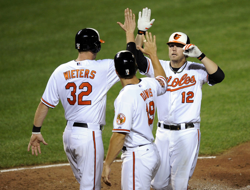 Baltimore’s Mark Reynolds gets a welcome after his three-run home run in the Orioles’ 7-1 win over Boston Tuesday at Camden Yards. Reynolds’ blast, his second of the game, came on the first pitch from reliever Mark Melancon.