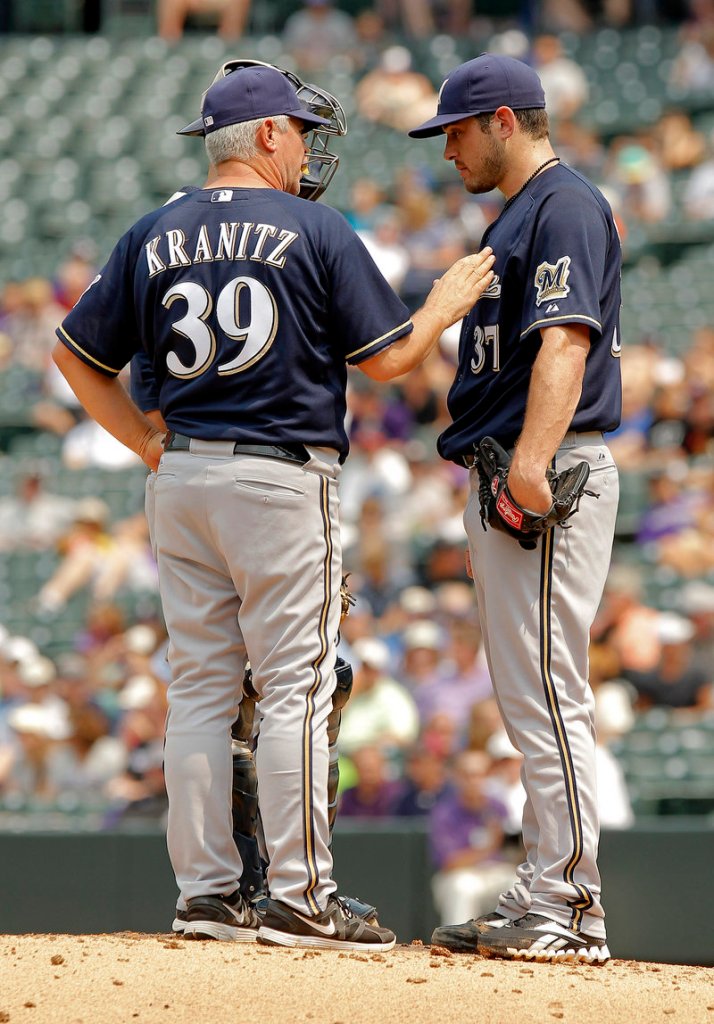 Milwaukee pitching coach Rick Kranitz confers with pitcher Mark Rogers as the Rockies scored three runs in the first inning and went on to win 7-6 at Denver.