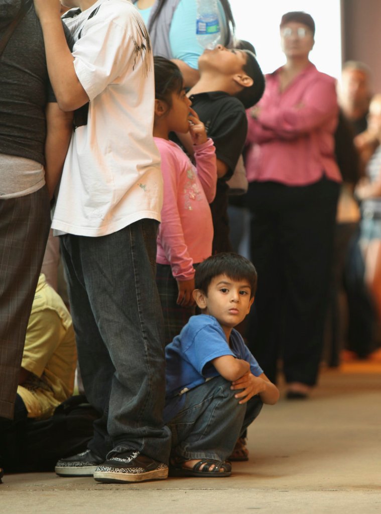 Children stand in line with some of the thousands of young immigrants at Chicago’s Navy Pier on Wednesday. “Navy Pier is today’s Ellis Island,” said Illinois congressman Luis Gutierrez, as a new federal program began.