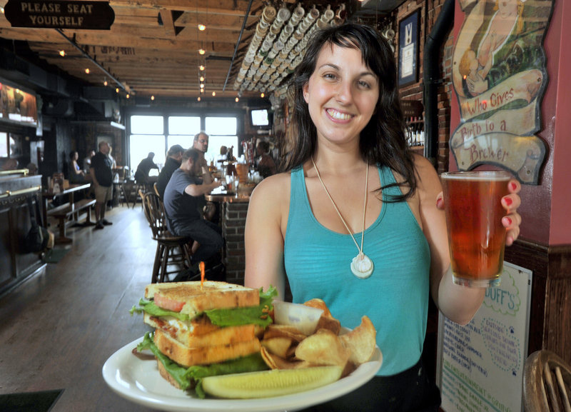 Server Michelle Blandina delivers a beer and a Chicken Stacker at Gritty McDuff’s Portland location on Fore Street.