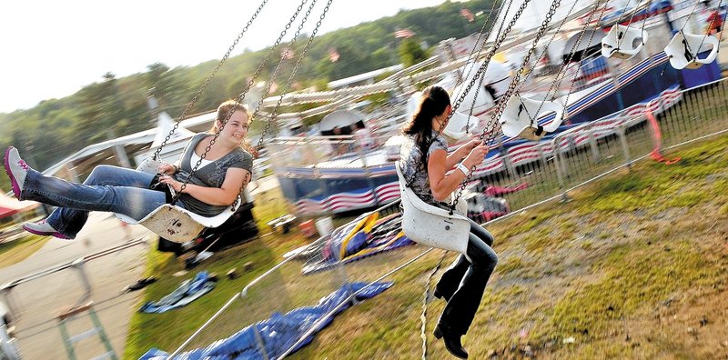 Michael G. Seamans/Morning Sentinel Krista Rogers, 19, left, and Megan Miville, 19, both of Fairfield, spin around on the Trapeze Swings at the Skowhegan State Fair on Wednesday.