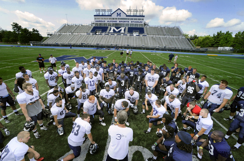 Practice is over for the day Friday, and University of Maine football coach Jack Cosgrove huddles with his players. The Black Bears are completing their first week of practice in preparation for the opener Sept. 8 at Boston College.