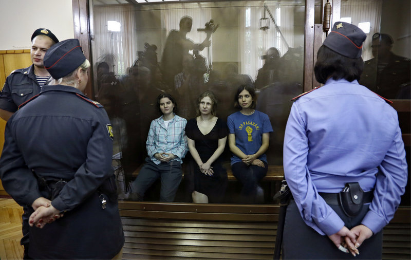 Members of the feminist punk group Pussy Riot, from left, Yekaterina Samutsevich, Maria Alekhina and Nadezhda Tolokonnikova sit in a glass cage in a Moscow courtroom Friday. They were convicted of hooliganism.