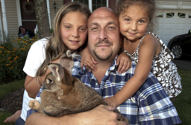 Kayden Lidsky, left, is shown with her father, Josh, sister Madison and Sandy, the family bunny, in North Haven, Conn.