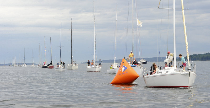 A parade of sailboats stretches down Casco Bay before the racing gets under way on Saturday. The annual Harborfest raises money for the National Multiple Sclerosis Society.