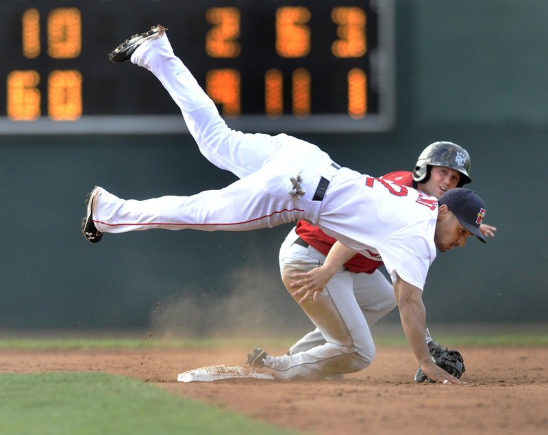 Sea Dogs second baseman Ryan Dent gets upended by Rene Tosoni of the New Britain Rock Cats but still completes a double play to end a 9-2 win in Game 1 of Saturday’s doubleheader.