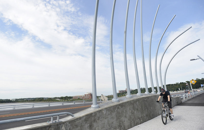 A bicyclist passes reed poles, an artistic element on Veterans Memorial Bridge in Portland.