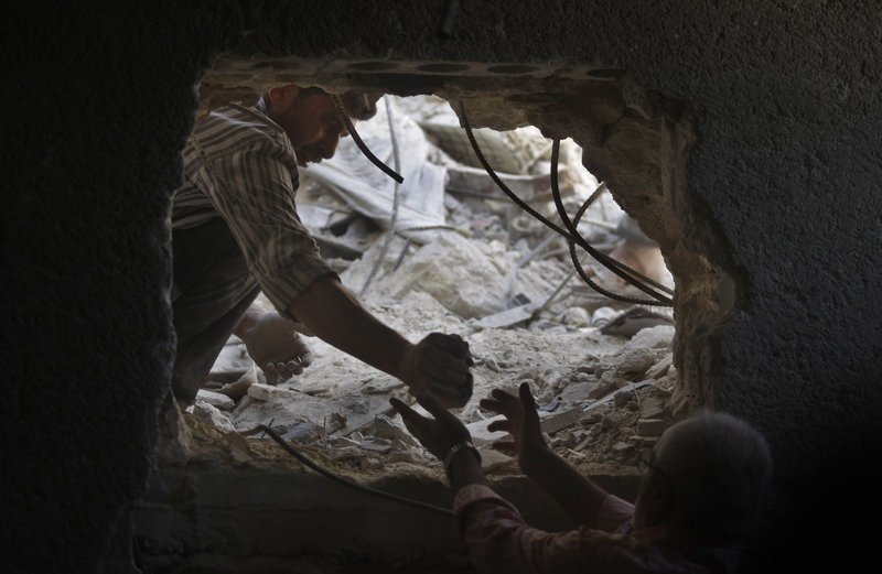 On Sunday, two men look for the bodies of two girls, ages 2 and 14, thought to be buried under the rubble of a building hit by a Syrian government airstrike in Aleppo.