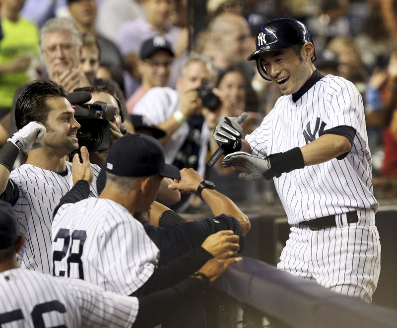 Ichiro Suzuki is greeted as he returns to the Yankees dugout after hitting his second home run of the game off Josh Beckett in a 4-1 victory Sunday night over the Red Sox.