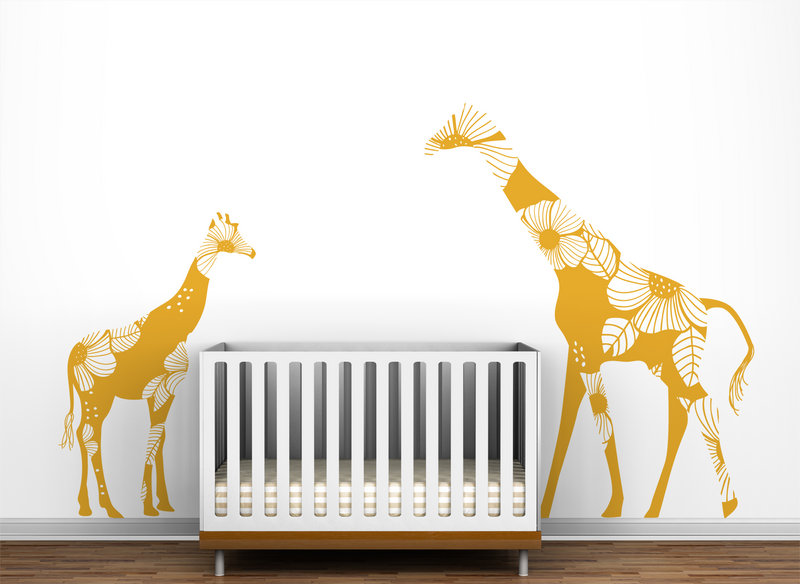Giraffe wall decals from Little Lion Studio appear to watch over a crib.