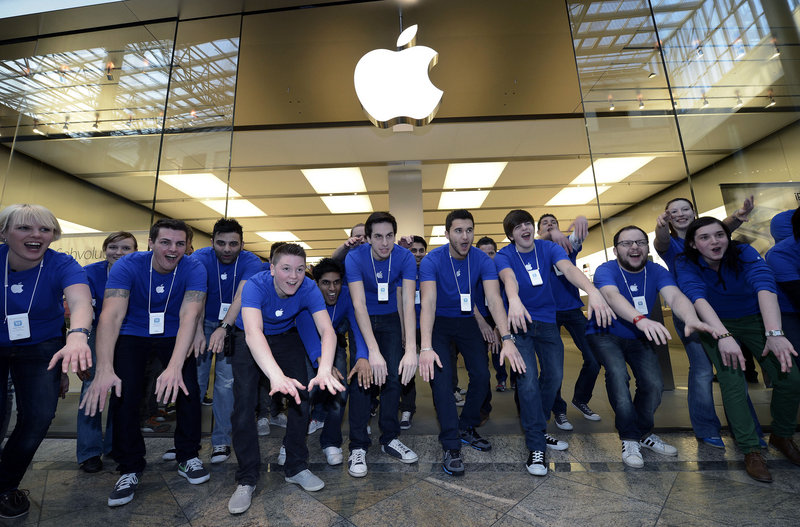 Apple employees greet customers in front of an Apple store in Oberhausen, western Germany, in March as the new iPad goes on sale there. On Monday, Apple set a new record for Wall Street’s most valuable company, riding on optimism about a possible impending iPhone 5 launch.