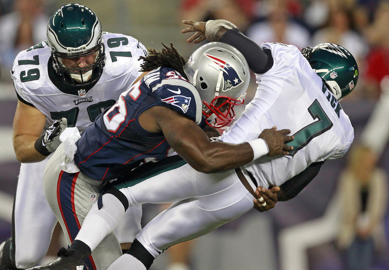 Jermaine Cunningham of the Patriots levels Eagles QB Michael Vick in Monday night’s preseason game at Foxborough, Mass. Vick left the game after the hit and had X-rays on his ribs, which were negative. The Eagles won without him, 27-17.