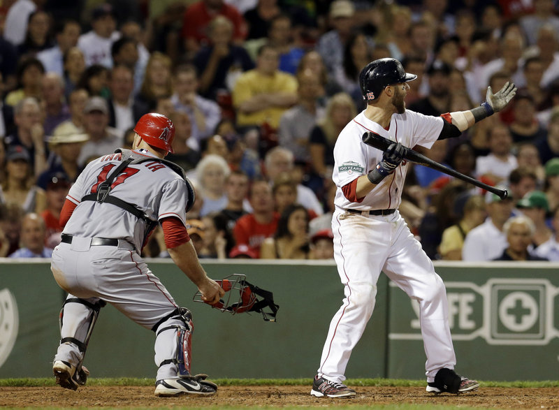 Dustin Pedroia of the Red Sox waves in Scott Podsednik, who scored from third on a wild pitch in the seventh inning as Angels catcher Chris Iannetta chases the ball.